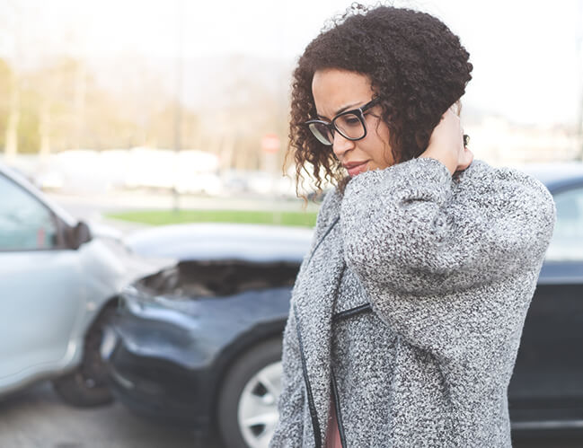 A woman feeling bad, holding her neck after having a car crash