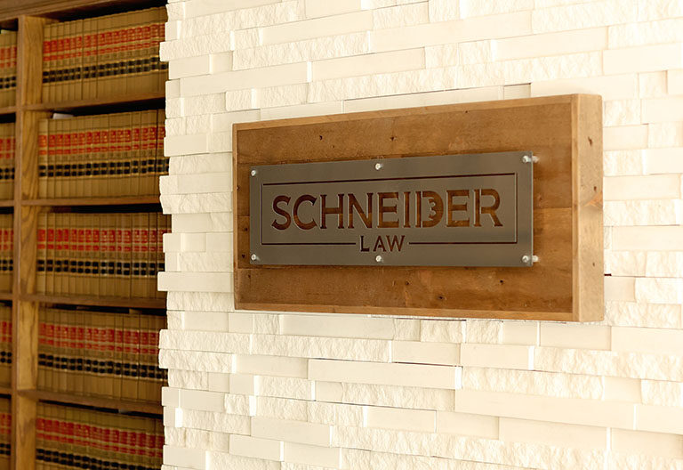Schneider Law Firm logo on plaque